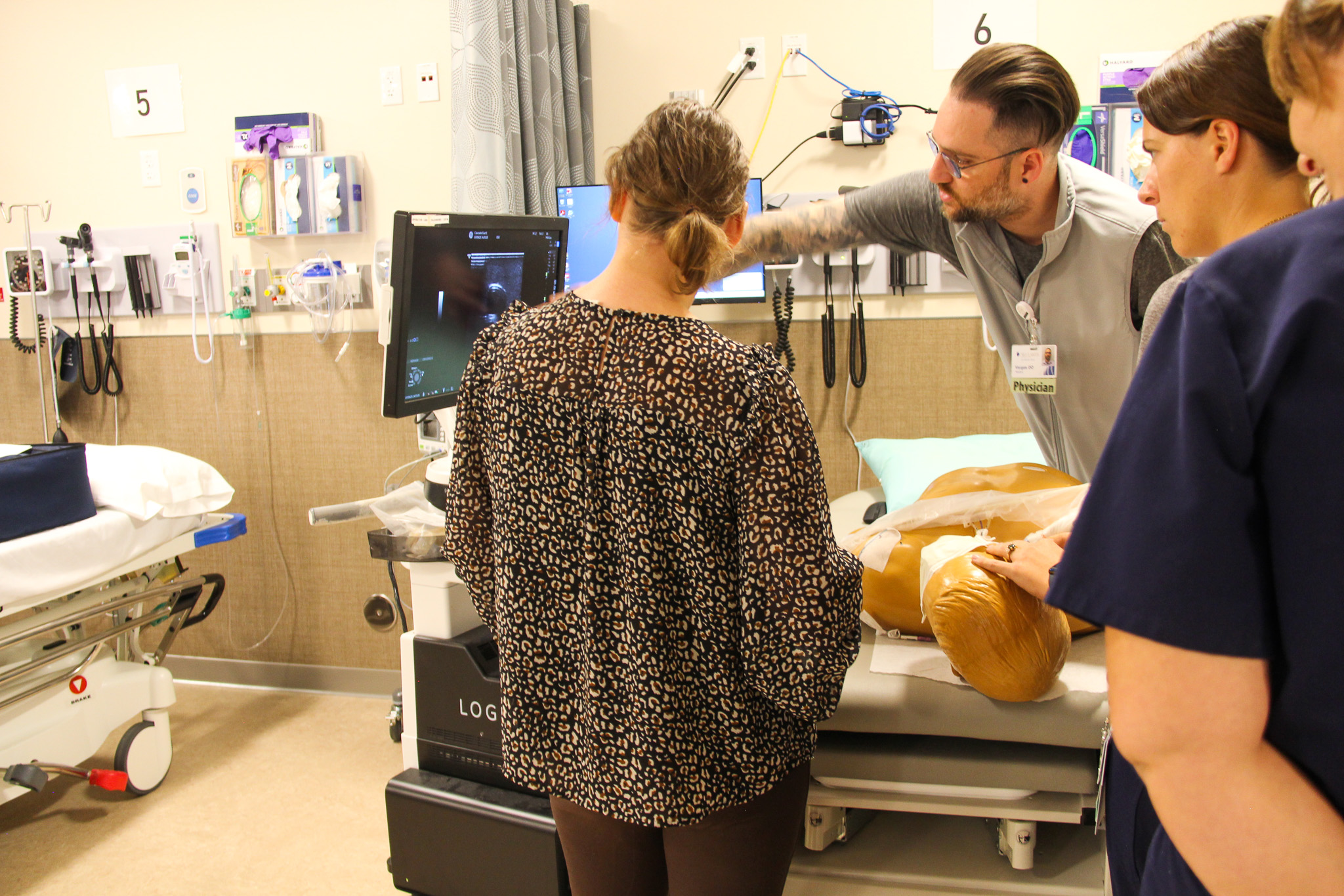 Providers gather around a teaching mannequin.