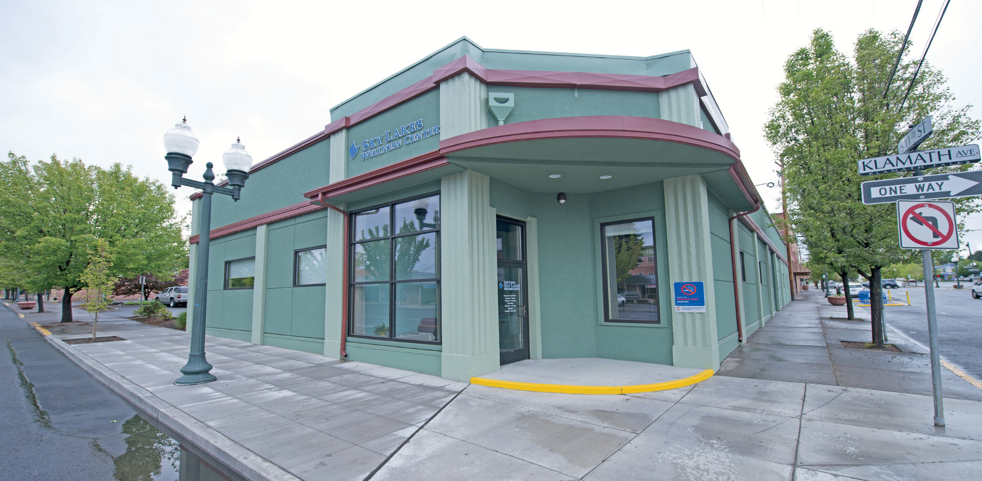 street view of the Sky Lakes Wellness Center. The Wellness Center is a green building on the corner of Klamath Avenue and 11th street.
