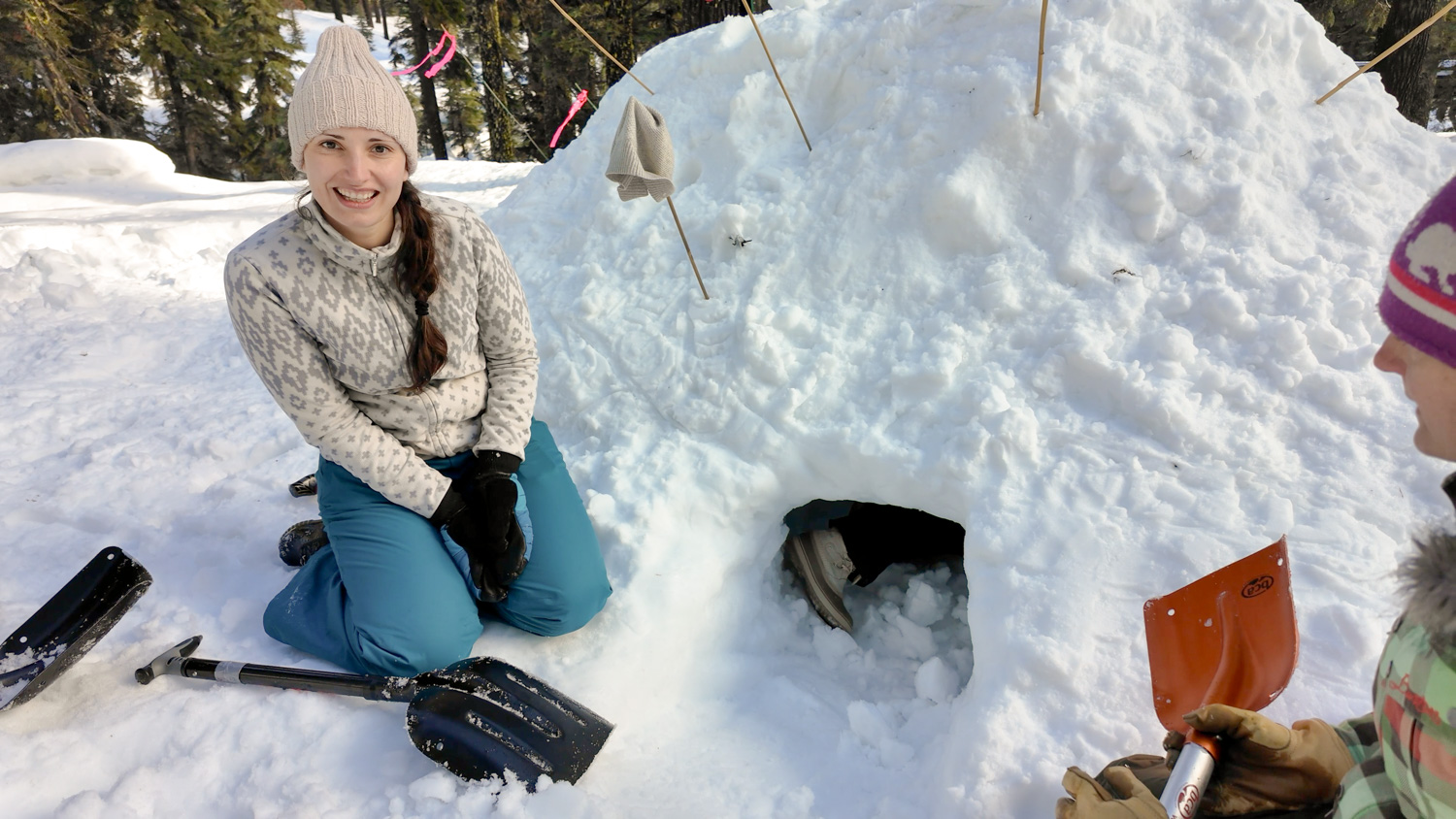 Dr. Anna Zandler next to a snow shelter she helped build